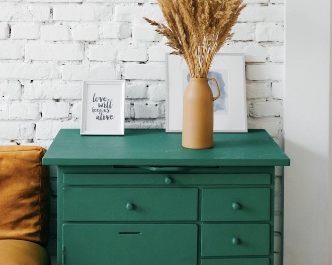 Green drawers with flowers and frames on top